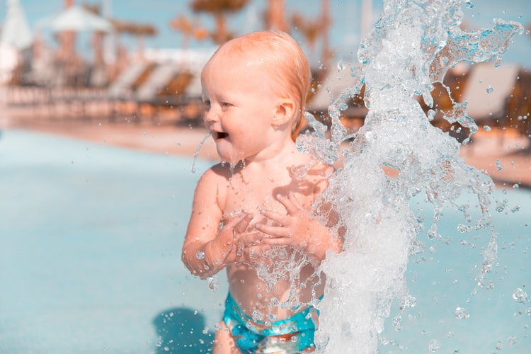 Get your baby comfortable by playing with them in the water.